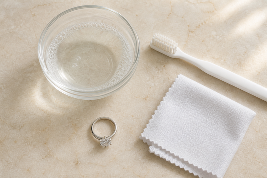 Safe moissanite jewelry cleaning tools including warm soapy water, an extra-soft brush, and a lint-free cloth