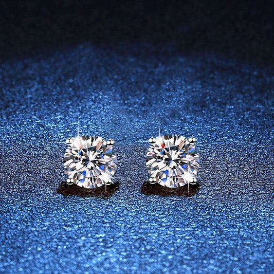Pair of round moissanite stud earrings in minimal four-prong silver settings