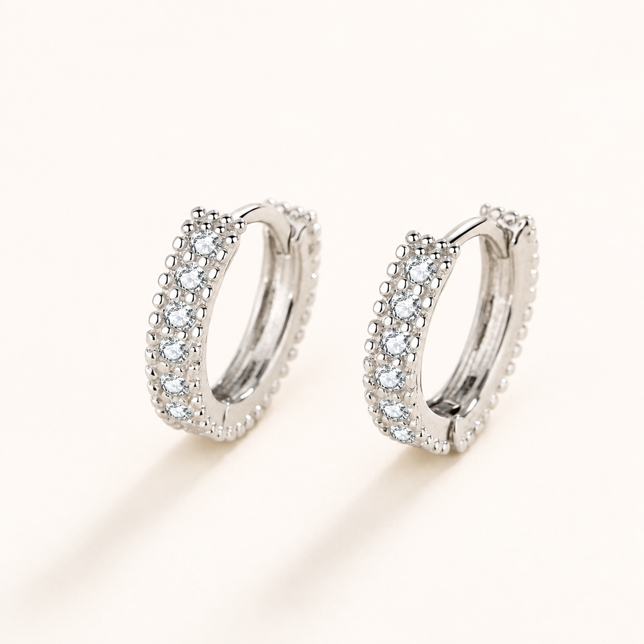 Pair of petite half-circle moissanite hoop earrings in polished silver