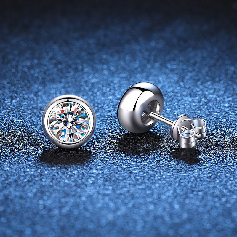 Pair of round moissanite stud earrings in smooth bezel style silver settings