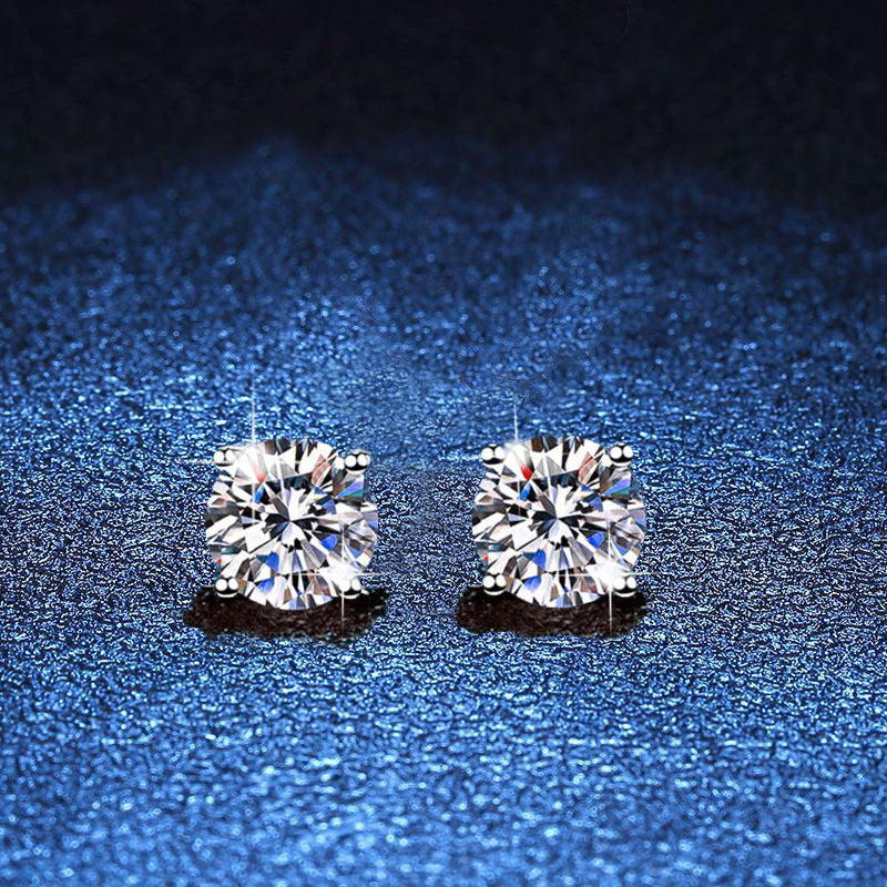 Pair of round moissanite stud earrings in minimal four-prong silver settings
