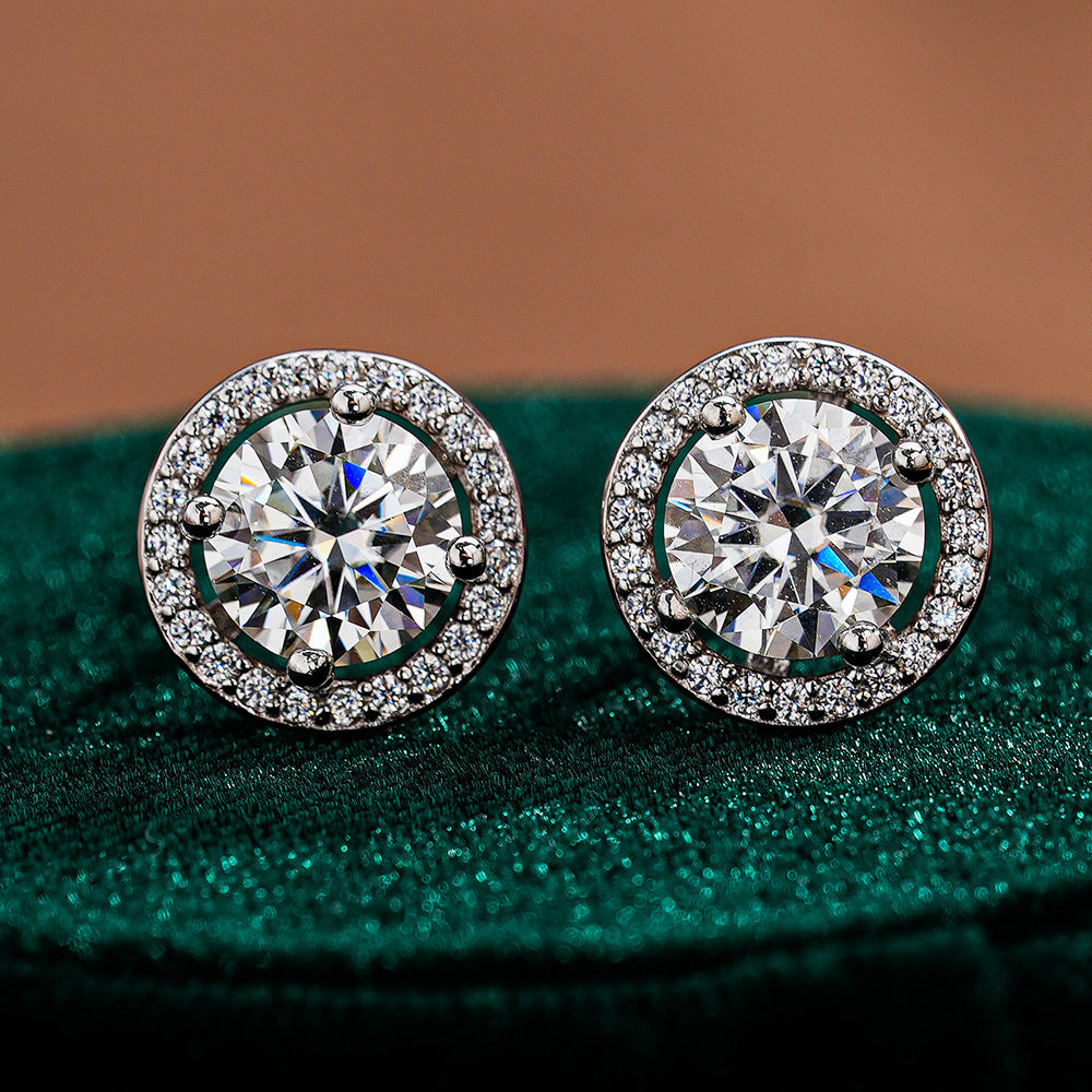 Pair of round moissanite stud earrings framed by circular halo accents