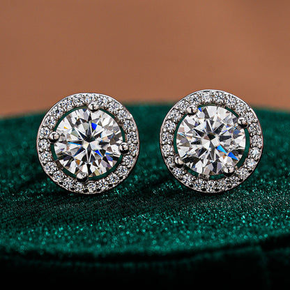 Pair of round moissanite stud earrings framed by circular halo accents