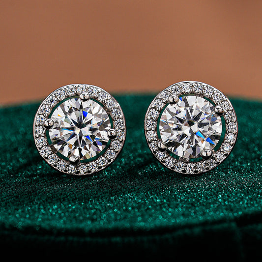 Pair of round moissanite stud earrings framed by circular halo accents